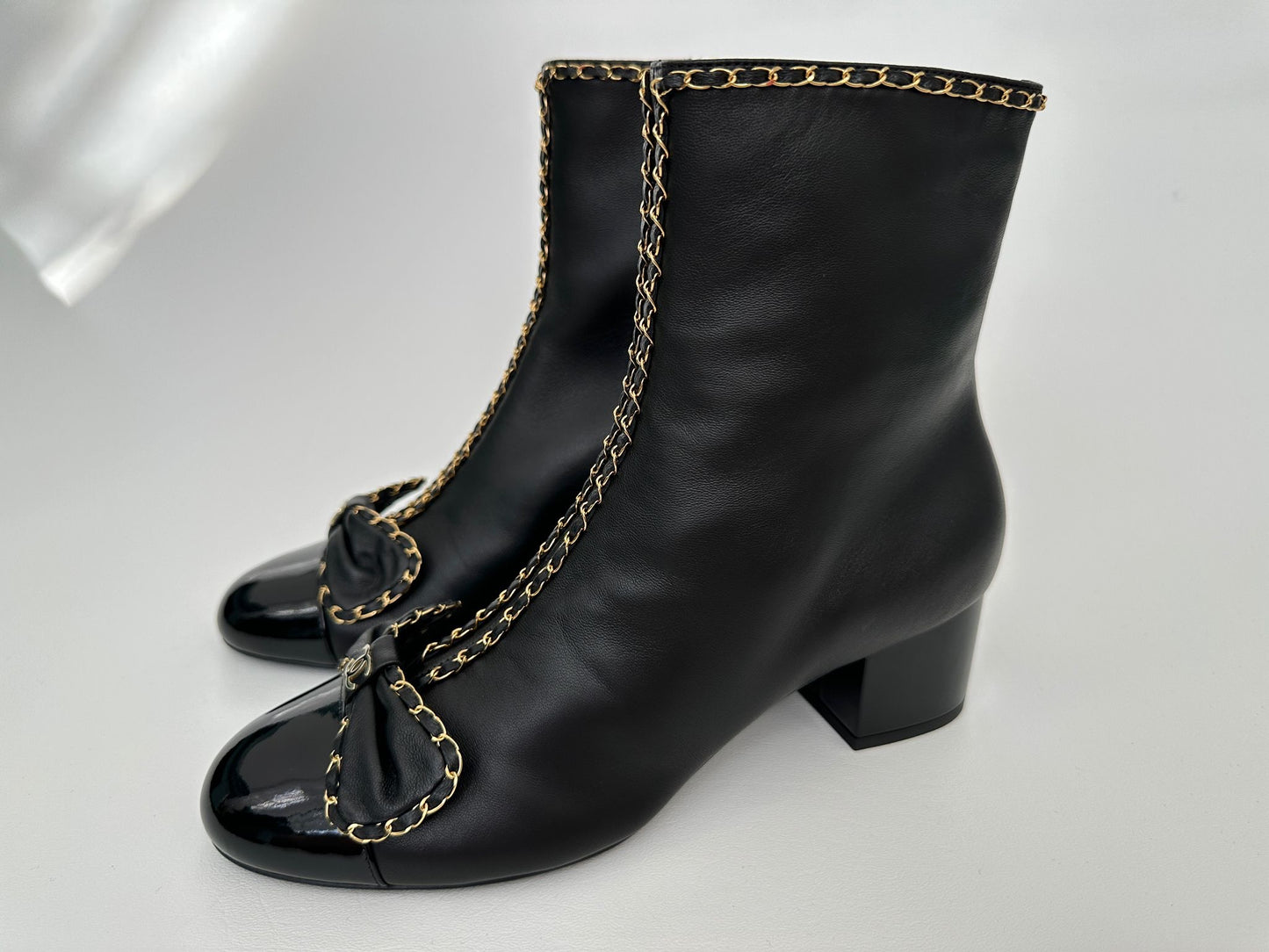 CHANEL 24B BLACK LAMBSKIN LEATHER SHORT BOOTIES WITH GOLD CHAINS AND BOW ANKLE SHORT BOOTS